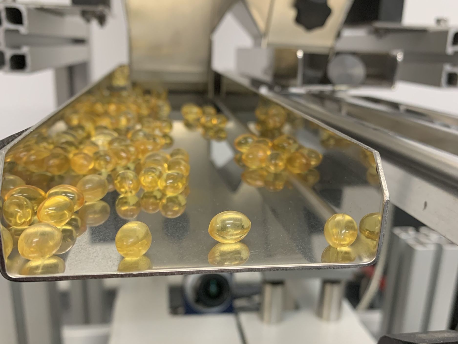 Bild 1 | Event-based Vision erkennt transparente Gelkapseln sicher als einzelne Objekte. Die Gelkapseln fallen aus einer Vibrationsrinne und werden mit hoher Geschwindigkeit von einer Zeilenkamera gezählt.