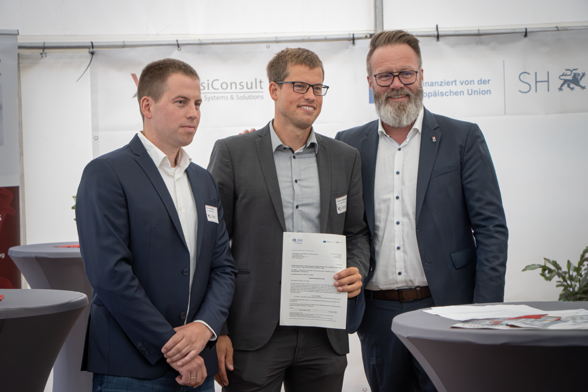 Bei der Übergabe des Förderbescheids für den VisiConsult-Neubau in Stockelsdorf (v.l.n.r.): Finn Schulenburg und Lennart Schulenburg (beide Gesellschafter sowie Geschäftsführer), Claus Ruhe Madsen (Minister für Wirtschaft, Verkehr, Arbeit, Technologie und Tourismus des Landes Schleswig-Holstein)