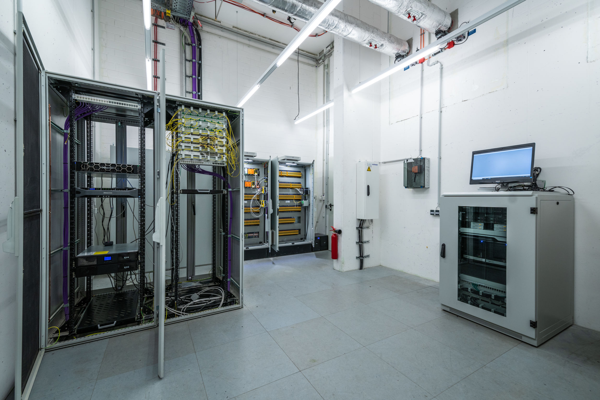 Gebäudeautomation für Mensch, Kunst und Kultur Im Keller des Humboldt Forum steht der Serverschrank mit der Hardware und Software für das Hochleistungs-BMS. Rechts im Serverschrank und hinten im Bild: Übergabeschränke und Brandmeldezentrale zur Entrauchungssteuerung: Sämtliche Informationen zur Entrauchungssteuerung und aller beteiligten Aktoren werden hier gesammelt und im gesamten Gebäude verteilt.