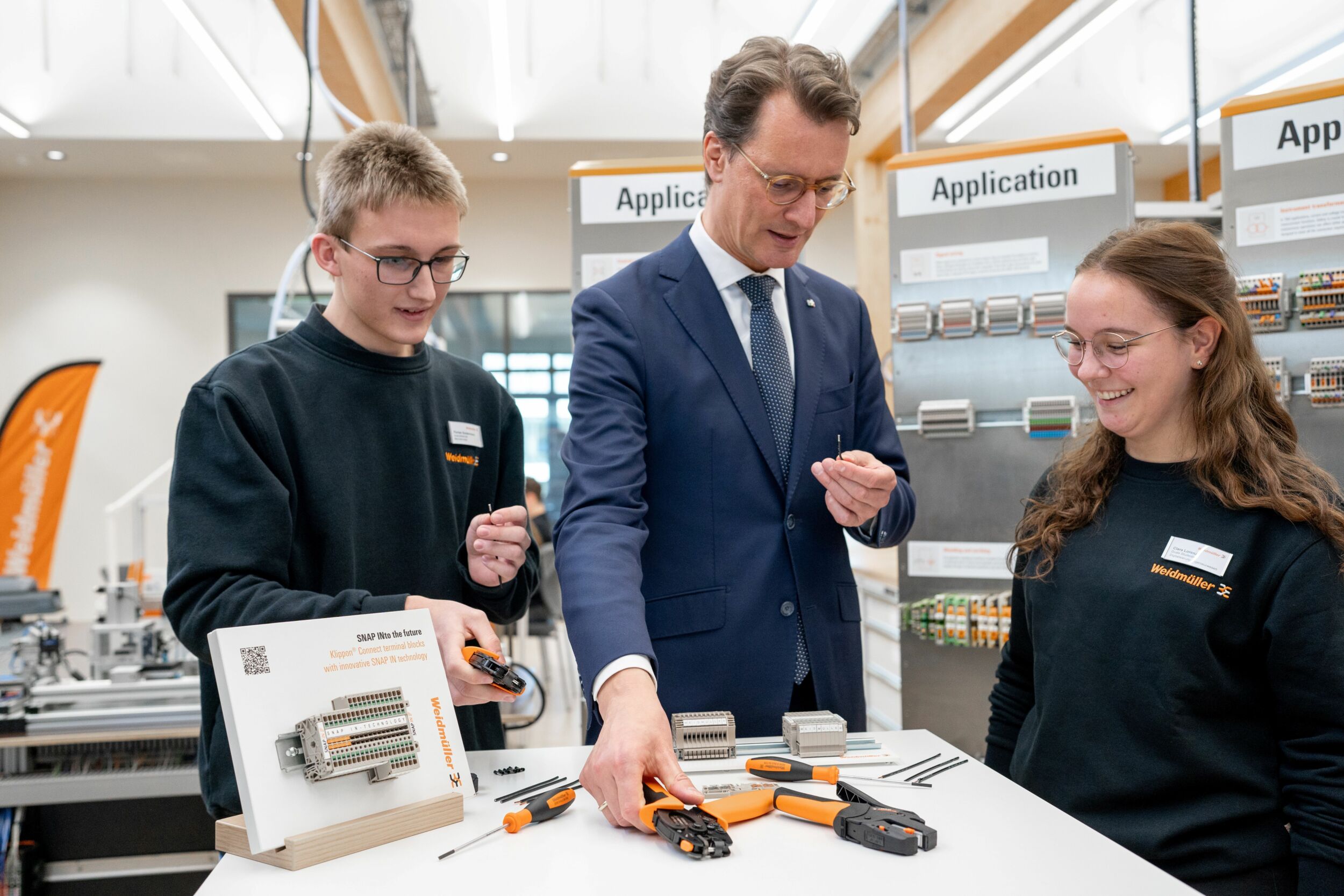 Bei seinem Weidm&uuml;ller-Besuch verdrahtete Ministerpr&auml;sident Hendrik W&uuml;st selbst mit der innovativen SNAP IN-Anschlusstechnologie &ndash; unter der Anleitung von Florian Sundermann, Auszubildender zum Mechatroniker, und Clara Lorenz, Dualstudentin Digital Engineering und Auszubildende zur Mechatronikerin.