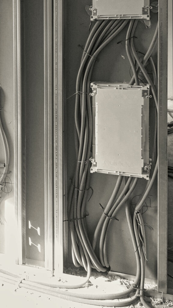 Vergleich im Trockenbau: Links eine unstrukturierte und unübersichtliche Installation um die Verteileranlage herum, rechts die saubere und sichere Befestigung der Wellrohre mit der TS Teleskopschiene.