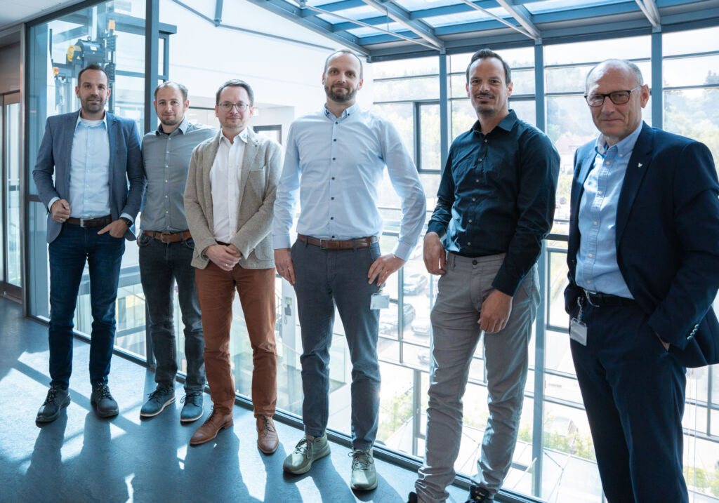 Trilux und Otto Fuchs KG kooperieren in einem Forschungsprojekt, um aus den Aluminium-Rastern
alter Leuchten neue Leuchtenprofile zu entwickeln. Vertreter beider Partner trafen sich zum Austausch &uuml;ber
den Projektfortschritt.
(v.l.n.r.: Sebastian Tr&auml;gner (CTO Trilux), Dr. Sebastian Wurth (Entwicklungsingenieur bei Otto Fuchs),
Dr. Ing. Lukas Kwiatkowski (Leitung Vertrieb Industrials bei Otto Fuchs), Patrik Bieker (Leiter Produktund
Technologieentwicklung bei Otto Fuchs), Thomas Schreiber (Trilux Design & Concept Team),
J&ouml;rg Ihne (CTO Entwicklung & Digitalisierung Otto Fuchs).