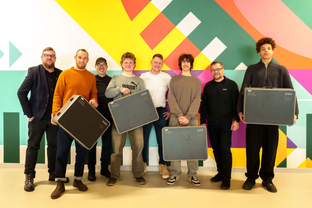 Smart Home im Schulunterricht: Die f&uuml;r die Region Berlin-Brandenburg zust&auml;ndigen Gira Vertriebsingenieure Peter Braun (2.v.r.) und Torsten Sandebeck (3.v.l.) &uuml;bergaben gemeinsam mit Andreas M&uuml;ller (4.v.r.) von Elektro M&uuml;ller aus Teltow vier Smart-Home-Schulungskoffer im Wert von zusammen rund 17.000 Euro an den Leiter der Grace-Hopper-Gesamtschule, Alexander Otto (l.), und Techniklehrer Nikolai Gregory (2.v.l.). Ab kommenden Schuljahr soll das Thema 'Geb&auml;udeautomation' auf Basis des Lehrplans fester Bestandteil des Technikunterrichts an der Schule werden. 