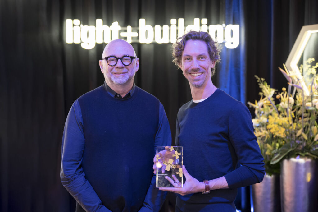 Erwinvan Handenhoven, Group Design Studio Director und DanielSpoenemann, Industrial Designer bei Hager nehmen denDesignplus Award by Light + Buildingentgegen.