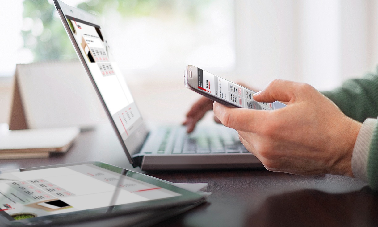 Close up of mans hands working at desk with electronic devices