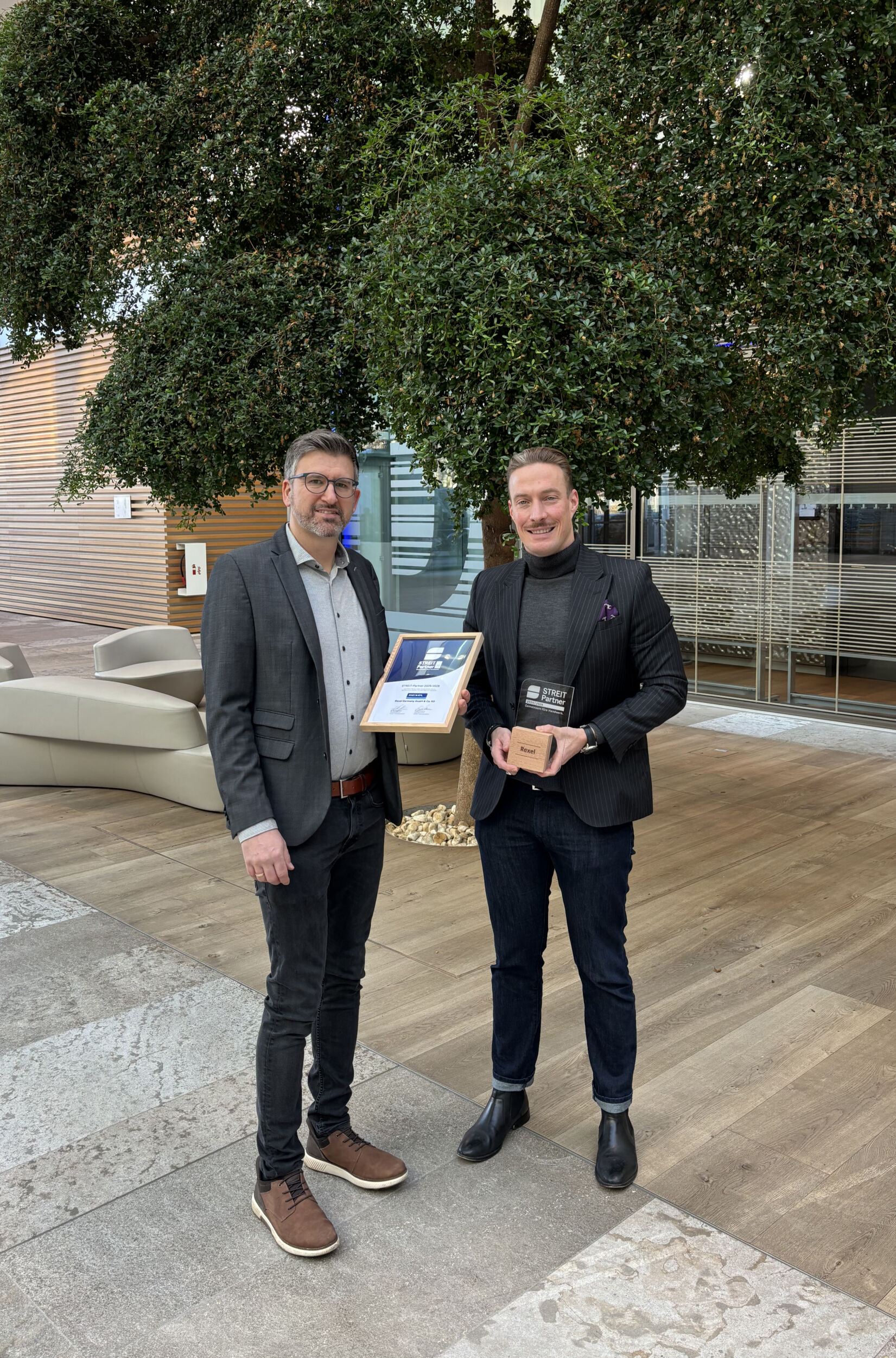 Partnerschaft besiegelt: Moritz Hamberger, Vertriebsmitarbeiter bei Streit Software übergibt die Urkunde für die Teilnahme am Streit Partnerprogramm an Thomas Griesbeck, Manager Digitale Services bei Rexel.