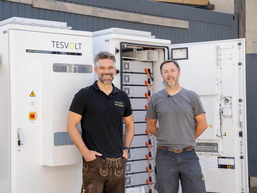 Markus Borke, Area Manager bei Tesvolt (links), und Matthias Poeting, Geschäftsführer von MP Elektrotechnik München bei der Installation der Gewerbespeicher auf der Festwiese.