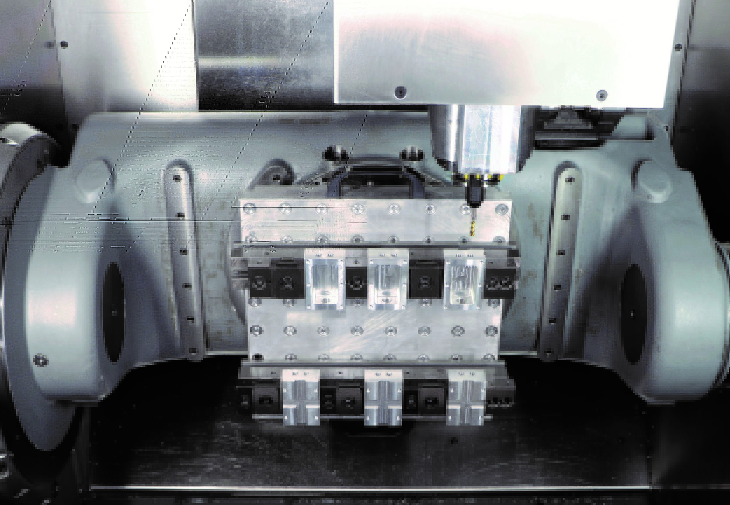 Das Mehrfach-Spannsystem auf einer Wechselpalette mit Rastersystem montiert, die auf einem Nullpunkt-Spannsystem abgesteckt ist (Maschine: Hermle C250).