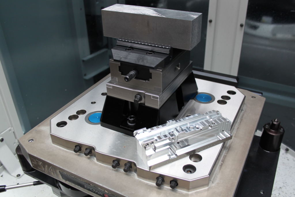 Das Spannsystem f&uuml;r die 5-Seiten-Bearbeitung basiert auf einer Wechselpalette mit Nullpunkt-Raster-Systemplatte gredoc NRS 6-fach. Darauf bauen eine Konsole gredoc eckig 1-fach und ein Zentrischspanner C2 125 L-160 mit Wendebacken Carbide-grip 3 mm auf.