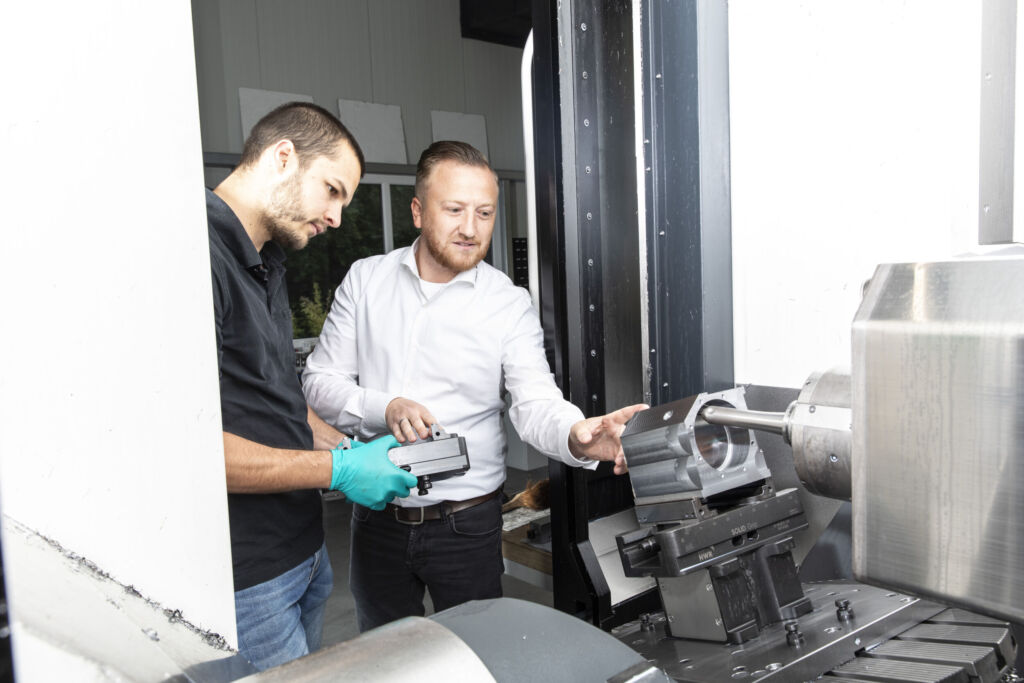 Kurze R&uuml;stzeiten und vielf&auml;ltige Kombinationsm&ouml;glichkeiten: Vorteile wie diese &uuml;berzeugen Zerspanungsspezialisten von den HWR-Nullpunkt-Spannsystemen aus der SolidLine: im Bild Niklas Z&ouml;pfgen (CNC Technik Heil) mit Alexander Michel (rechts) von HWR Spanntechnik.