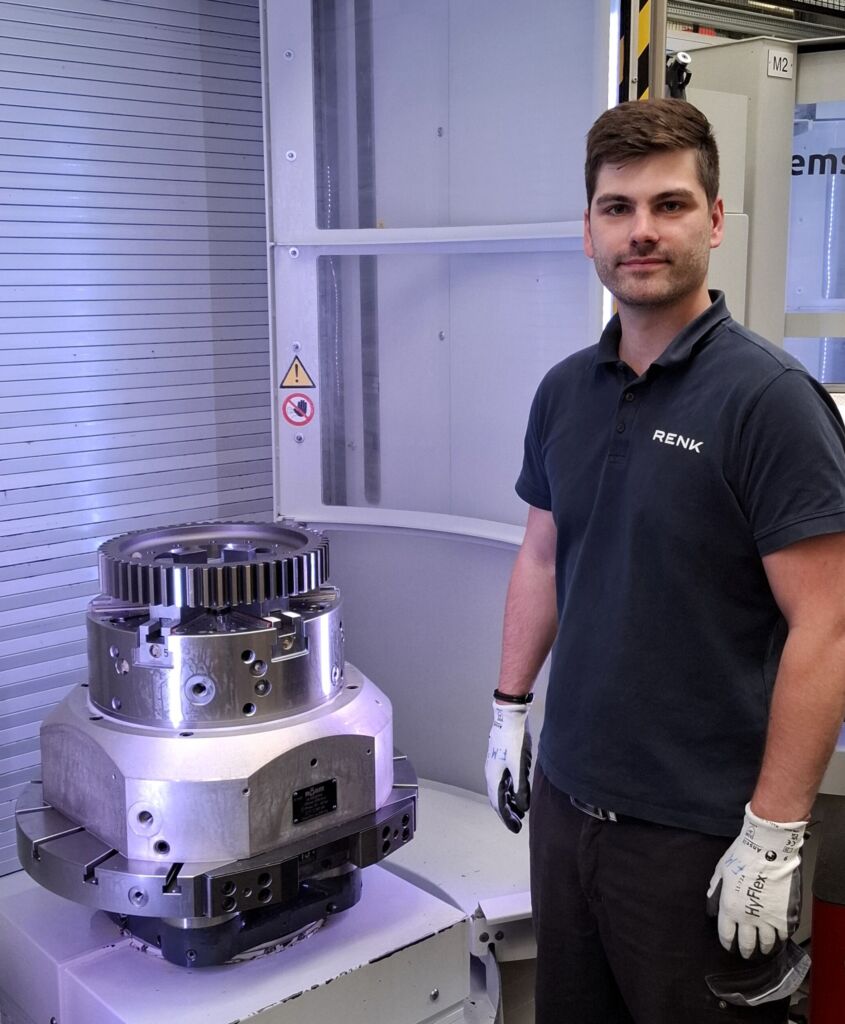 Zerspanungsmechaniker Fabio Michler vor dem mit R&ouml;hm-Backen gespannten Bauteil zur Bearbeitung.