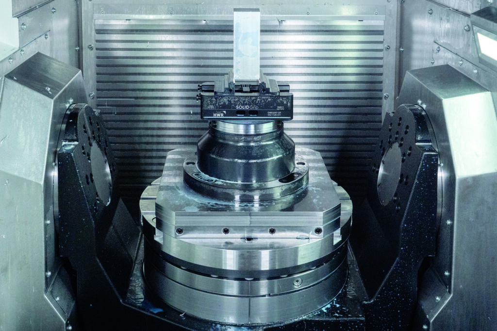 Ein Greifersystem entnimmt die vorbereiteten Schraubstöcke aus einem Magazin und setzt sie auf das Nullpunktspannsystem der Maschine. Grundlage dafür bilden 5-Achs-Zentrierspanner SolidGrip von HWR Spanntechnik, einem Unternehmen der Kipp Group. 