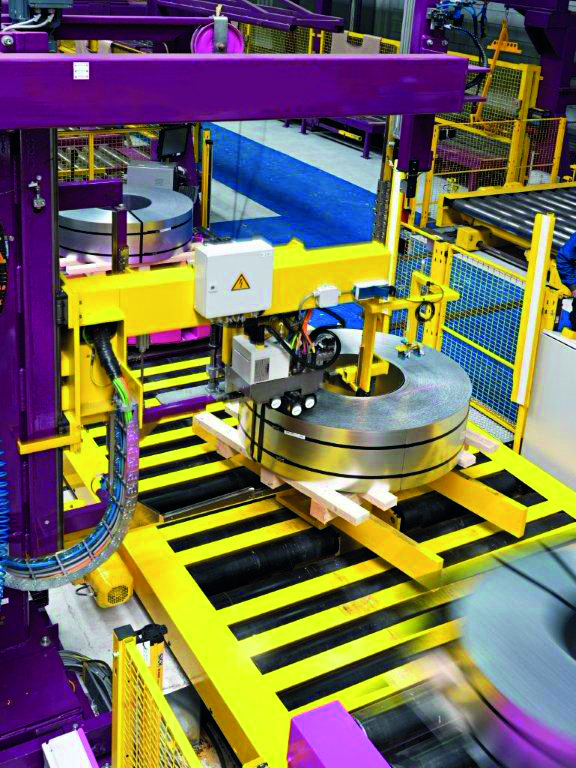 Umreifung durch das Coilauge: Stahlketten von Tsubaki Kabelschlepp führen die Motorleitungen und Gasschläuche für das Umreifungsaggregat.