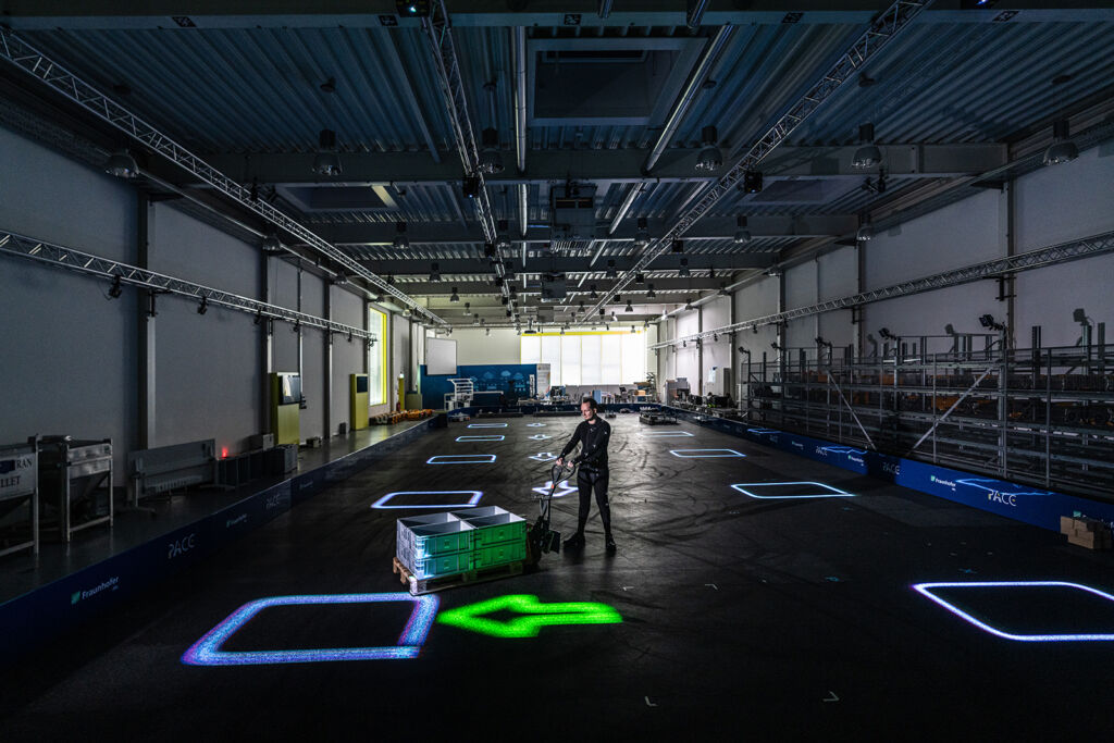 Das dynamische Leitsystem LARS wirft Informationen per Laserprojektion direkt auf den Boden der Lagerhalle.