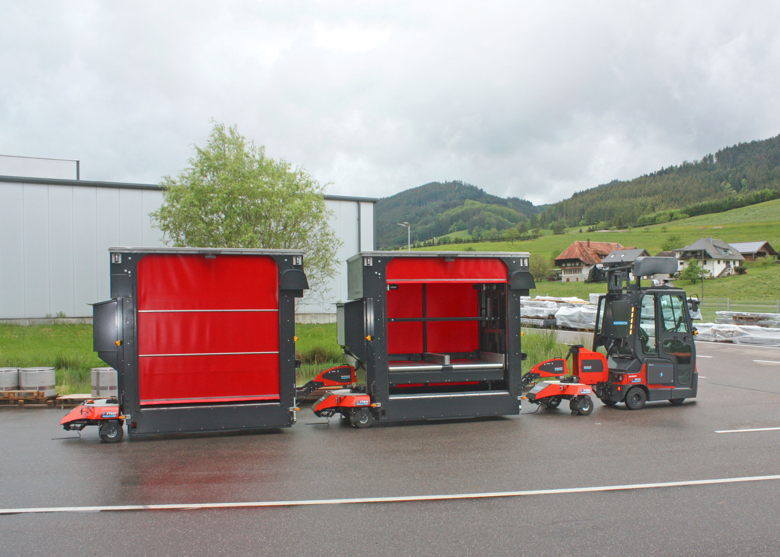 Vollautomatisierter und autonomer Outdoor-Routenzug Factory Train FT620 von Neumaier Industry mit Rollenbahn-Warenträger für die automatisierte Beladung von stationärer Fördertechnik bzw. Entladung auf stationärer Fördertechnik.
