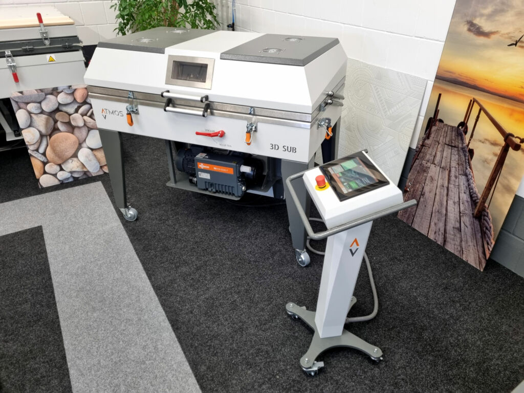 Oberflächengestaltung durch Sublimation in der Vakuumpresse 1 Die Atmos 3D SUB: Modernes Design trifft fortschrittliche Technik. Rechts im Bild: Eine sublimierte Zimmertür aus Glas.
