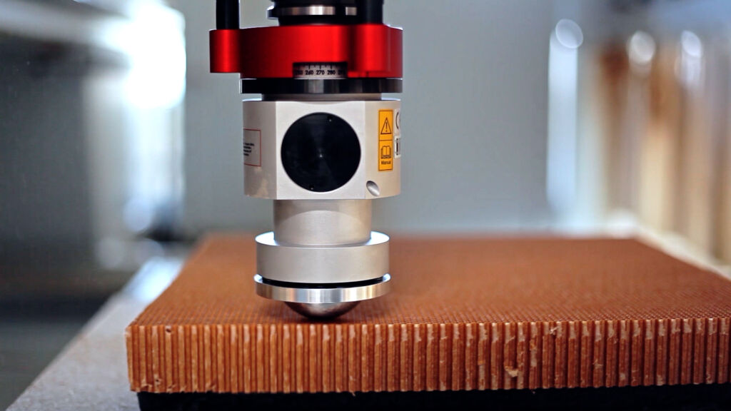 Weiche Materialien mit Messern und Klingen schneiden 6 Das Soft Cutter Pro Function Line-Aggregat beim Schneiden von Filz (dunkles Material), Schaumstoff (weißes Material) und Honey Comb (gelbliches Material).