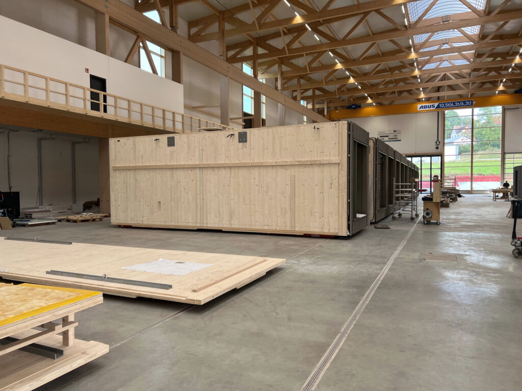 Modularer Holzbau auf sechs Spuren 1 Im One-Piece-Flow-Verfahren kann Baumgarten in seiner neuen Werkhalle bis zu 600 Raummodule jährlich fertigen.