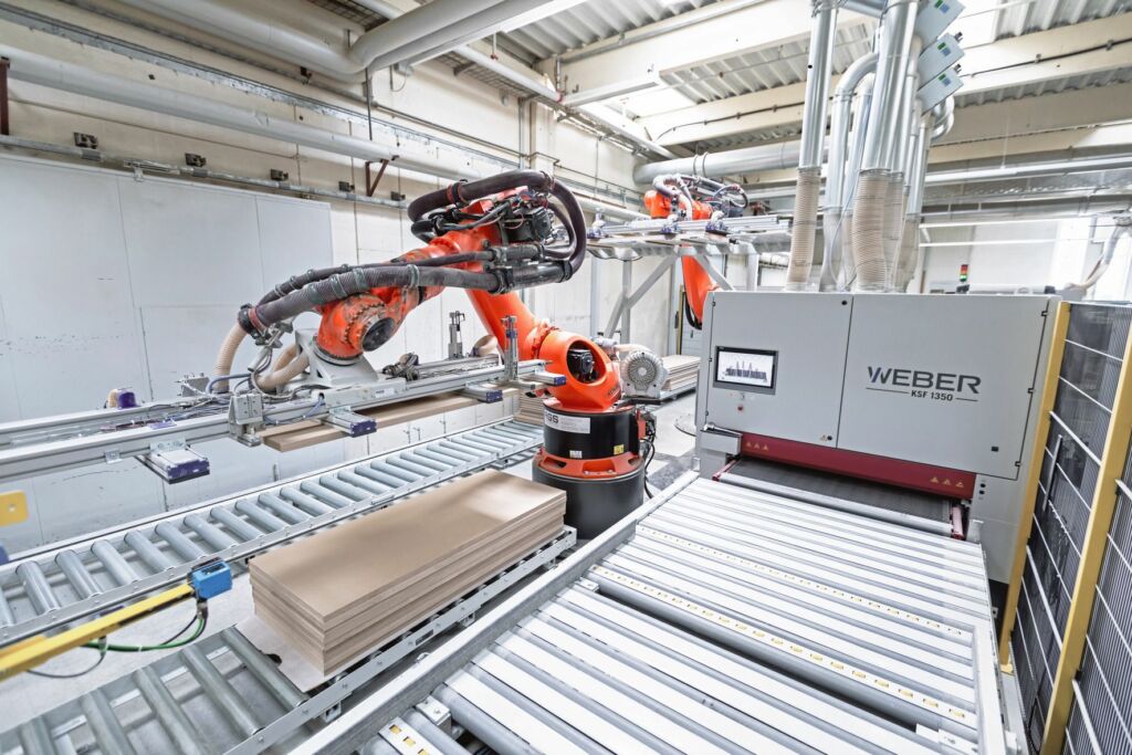 Von Tür zu Tür 5 Während der erste Roboter die Schleifmaschine belädt, legt der zweite Roboter bereits den nächsten Rohling auf das Gestell.