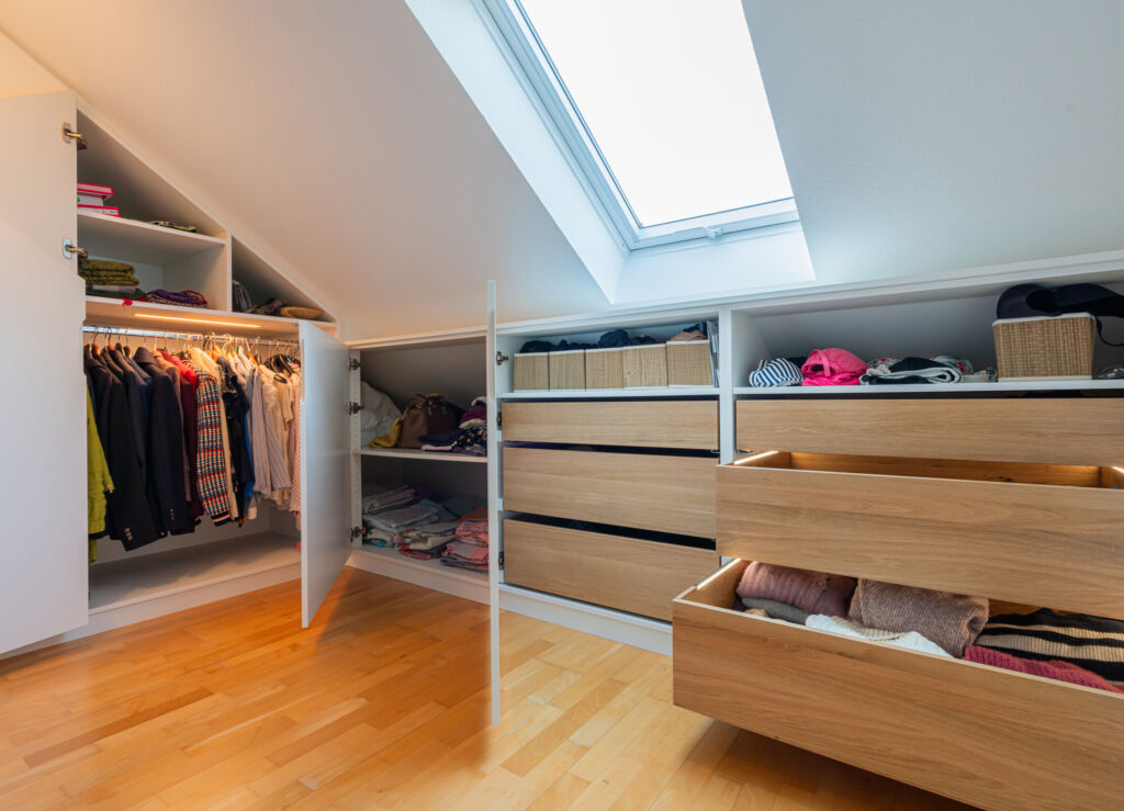 Alle Leuchten im Schrank? 1 Den Bereich direkt unter der Dachschräge gestaltete Hennemann mit Fachböden und Holzschubkästen in Eiche, die auf der Actro-5D-Führung von Hettich laufen.