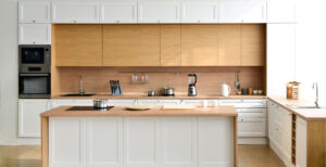 Modern new light interior of kitchen with white furniture and table.