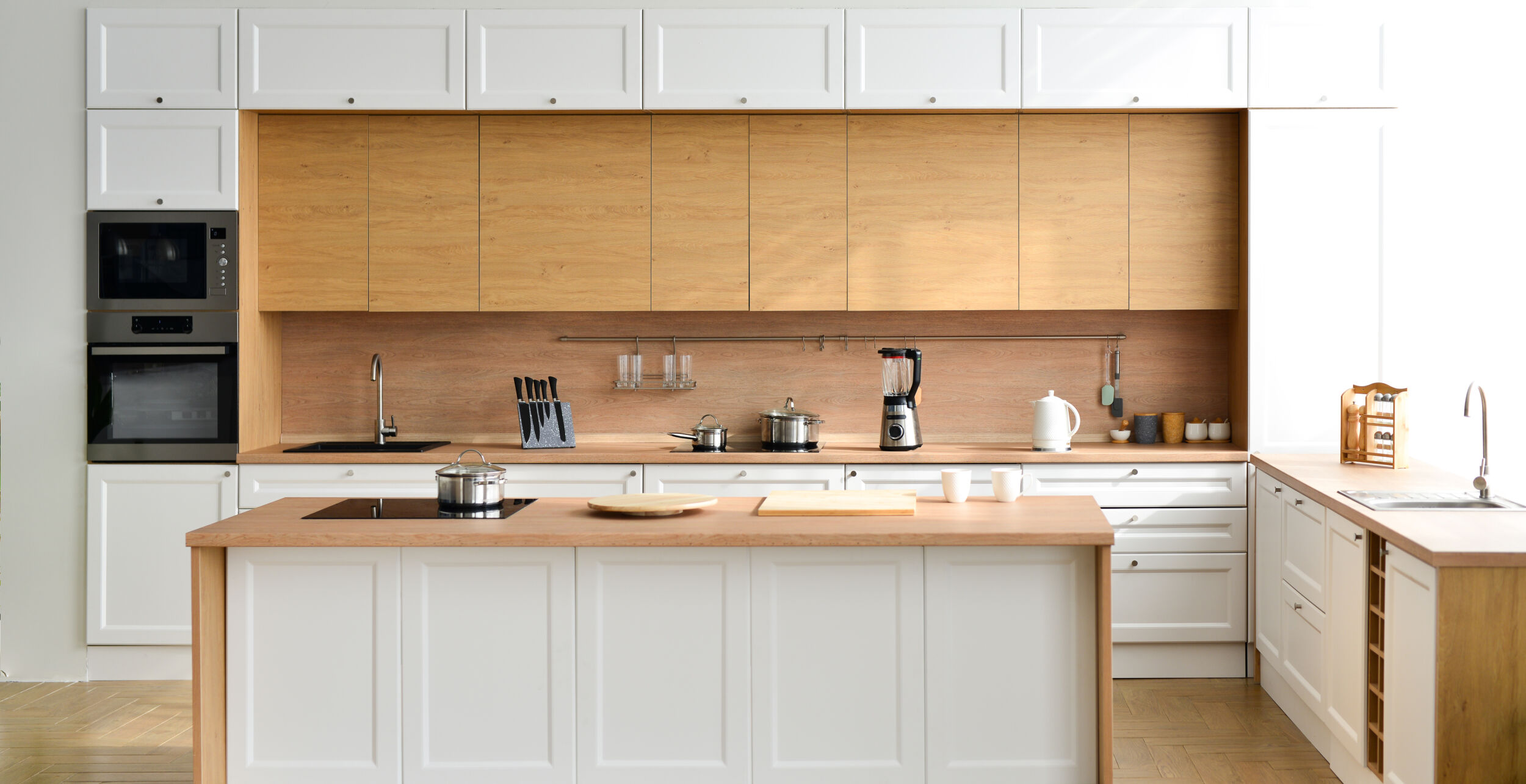 Modern new light interior of kitchen with white furniture and table.