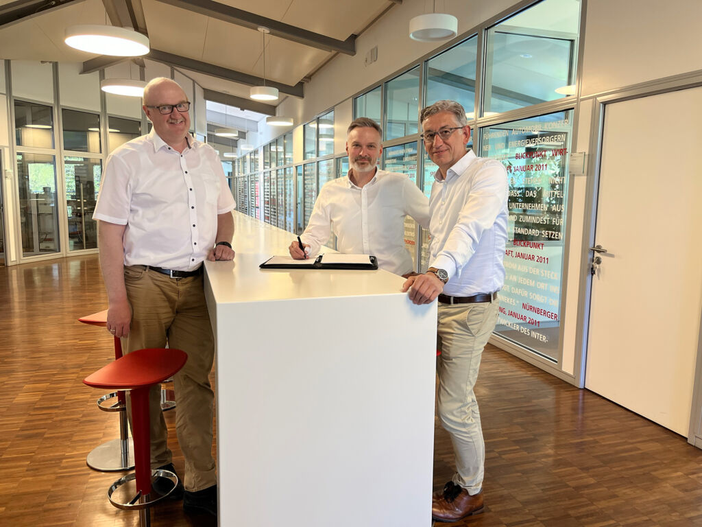 Christoph Epe (Geschäftsführung Mennekes), Christopher Lehne (Geschäftsführung Charge-V) und Volker Lazzaro (Geschäftsführung Mennekes) bei der Vertragsunterschrift des Asset Deals.