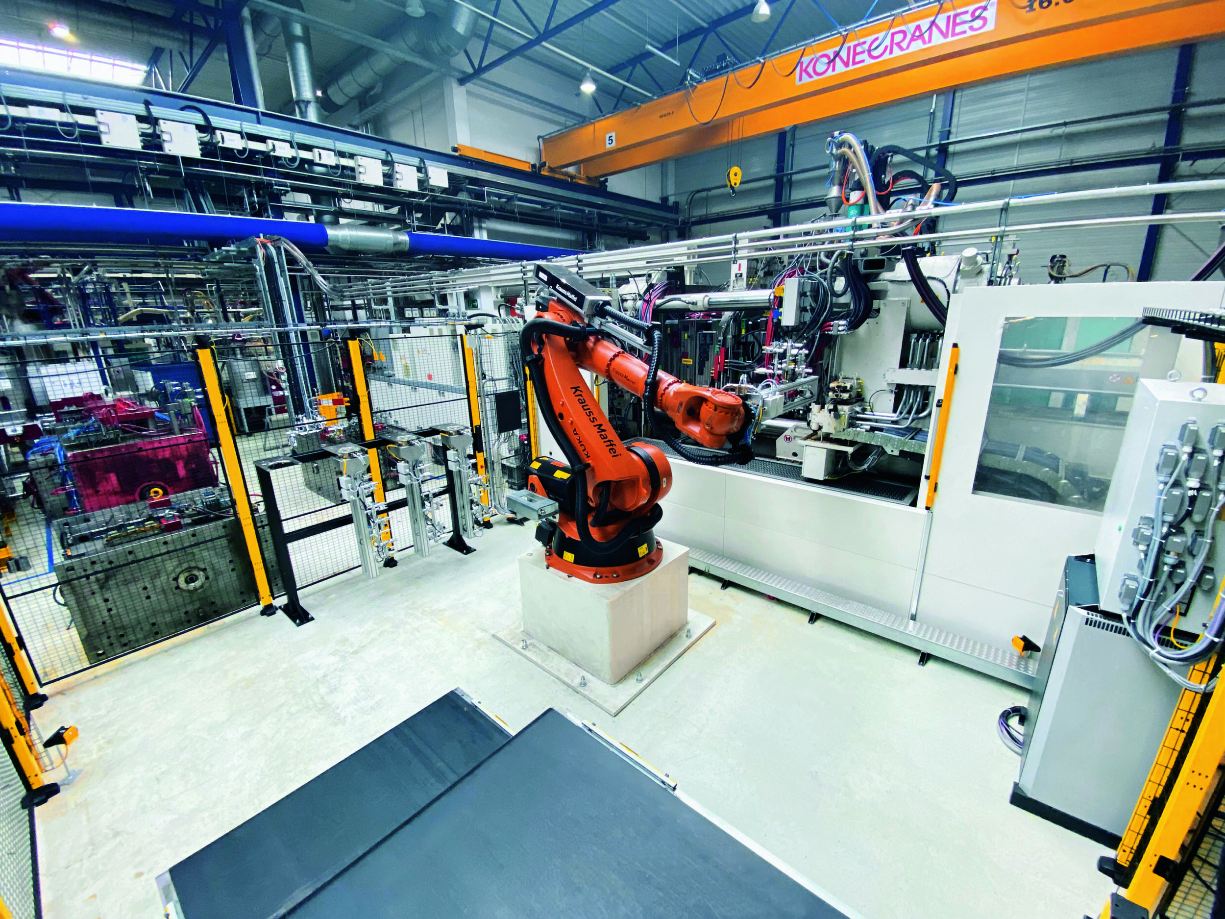 Sicher im Schutzraum mit Pilz-Radarlösung: Roboter am Entnahmebereich der Spritzgießmaschine bei Weiplas, im Vordergrund das Transportband.