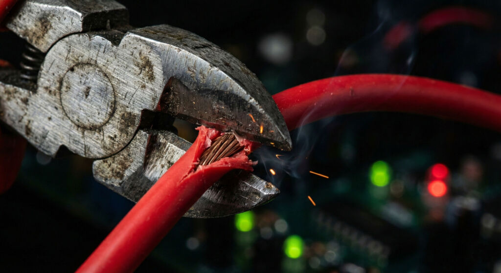 Wire Cutters Cutting Red Electric Cable with Sparks