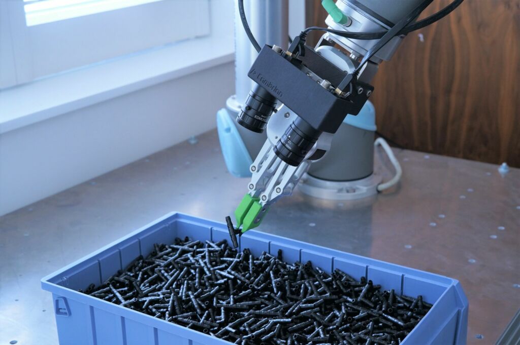 Ein Roboterarm lokalisiert und greift Teile mithilfe zweier IDS-Kameras und intelligenter Cambrian-Software.