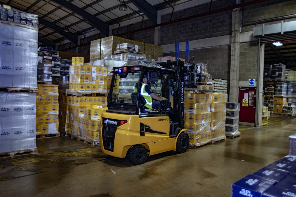 Hyundai 35B-9U beim Umschlag von Paletten mit Whisky-Kartons. Mit der Cascade-Mehrfachklammer werden vier Paletten transportiert.