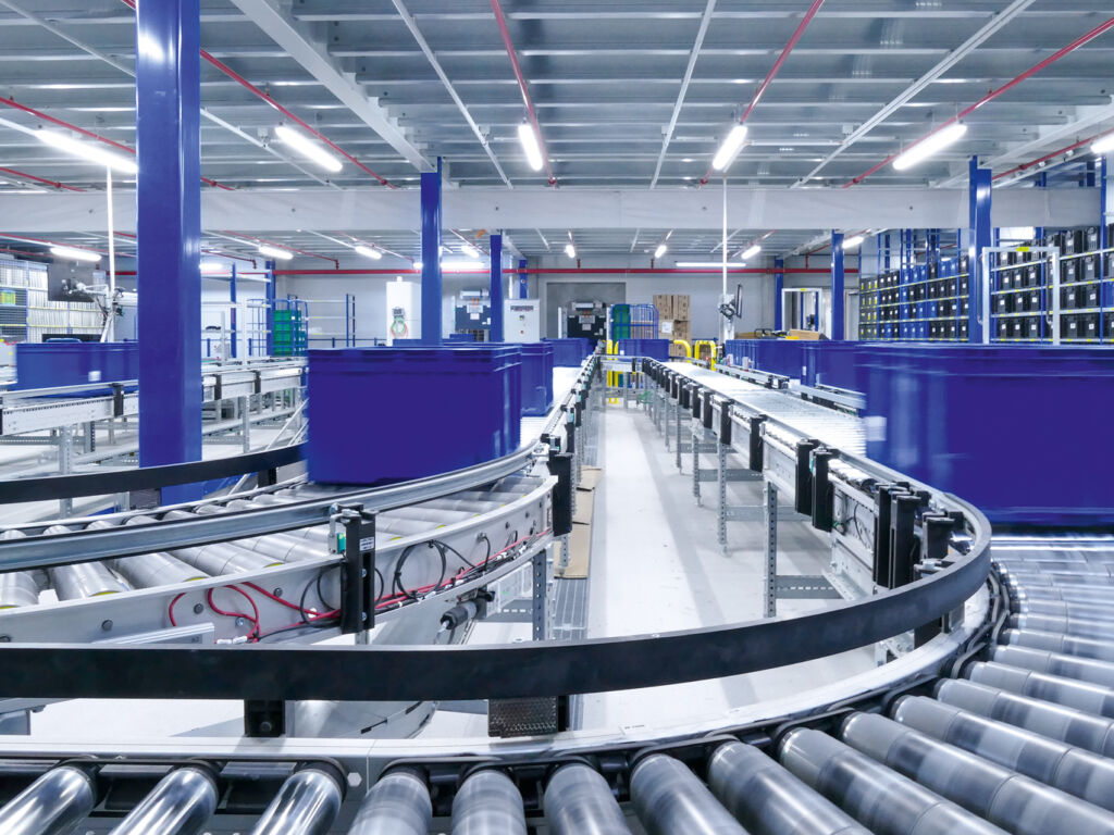 In der neuen Logistikhalle werden Transportkisten auf mehreren Förderstrecken kommisioniert.