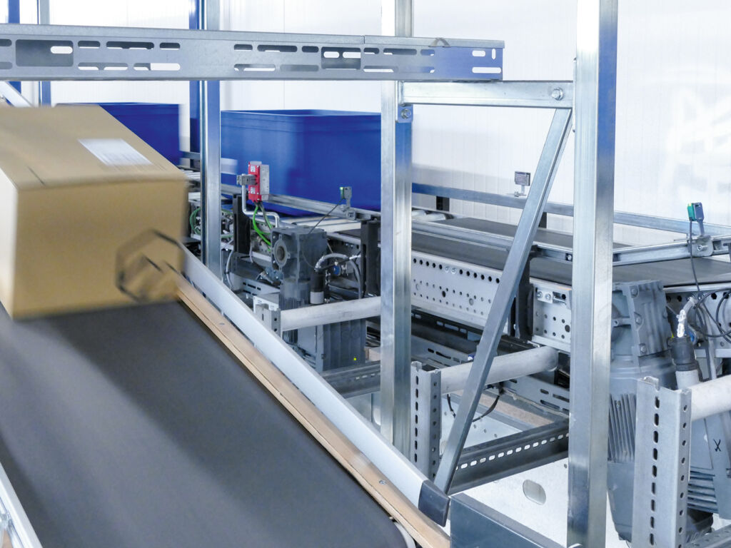 Auf dem Kartonagenabzugsband werden die Versandpakete nach der Kommissionierung weiterbefördert. Mehrere Getriebemotoren der Baureihe Movimot von SEW-Eurodrive treiben das Band an.