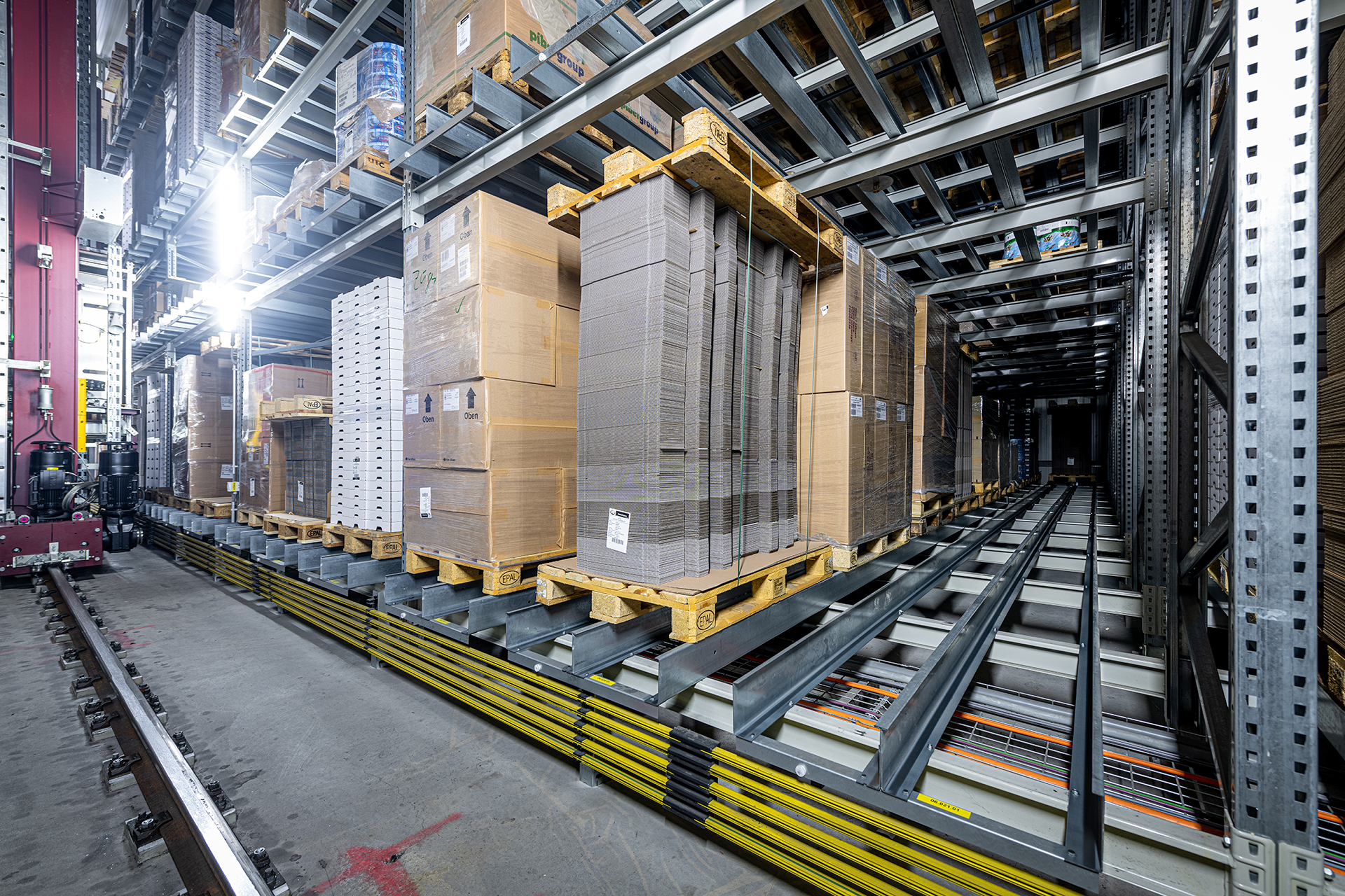 Ein Satellitenlager von Westfalia Technologies - hier das Verpackungslager von Züger Frischkäse - lagert hochkompakt und materialschonend. Dank der mehrfachen Schienenauflage in den Lagerkanälen halten Paletten länger. Das verhindert Störungen und Ausfall