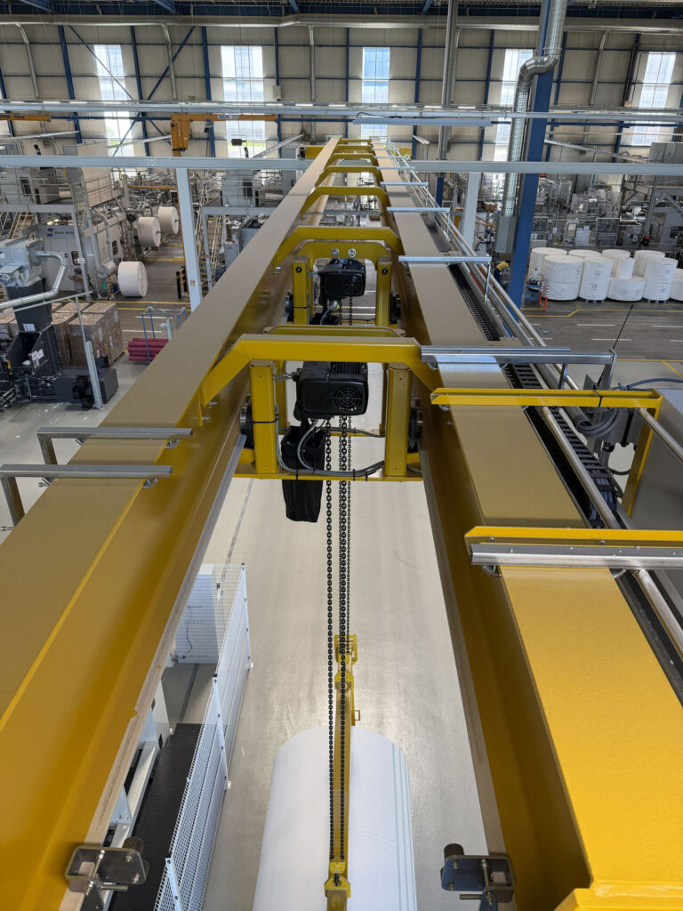 Die beiden Hubwerke, zwei GIS Elektrokettenzüge vom Typ GP1000, sind platzsparend zwischen den Stahlträgern der Kranbrücke angebracht.