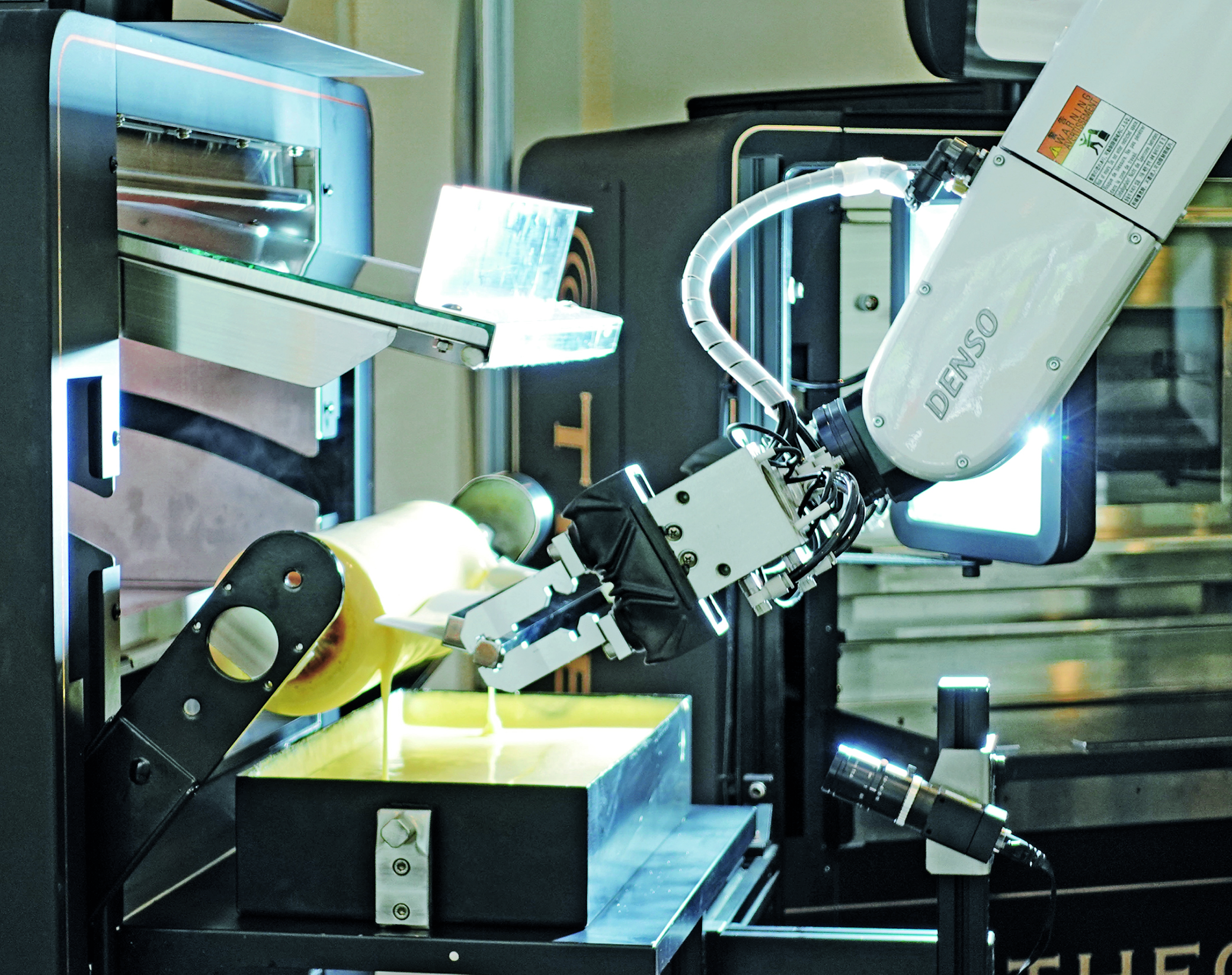 Baumkuchen 4.0 2 Der Roboter erledigt das Abstreifen des Teigs nach dem Auftragen einer neuen Baumkuchenschicht sehr präzise.