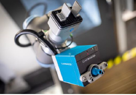 Kleiner Antrieb, große Wirkung 2 Der Clampbooster in Action, montiert an einem Cobot vor einer Fünfachs-Maschine.