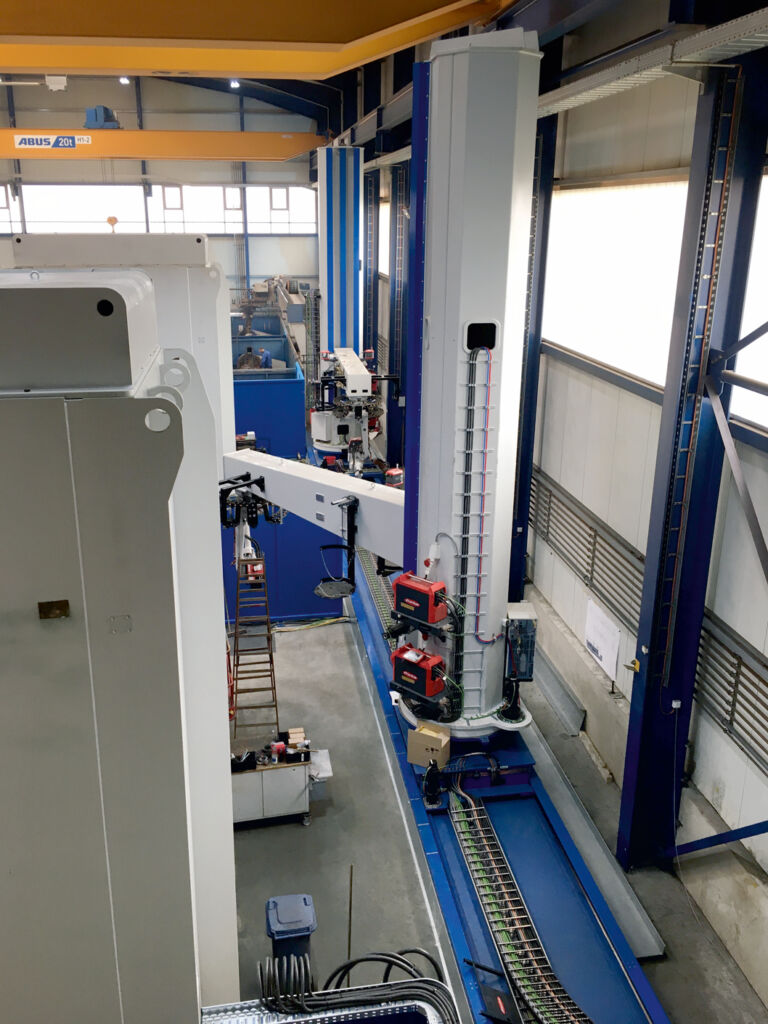 Auf der Linearachse verfahren zwei Portale. Am Ausleger, der über Hub- und Drehachsen bewegt wird, ist der Schweißroboter angebracht.