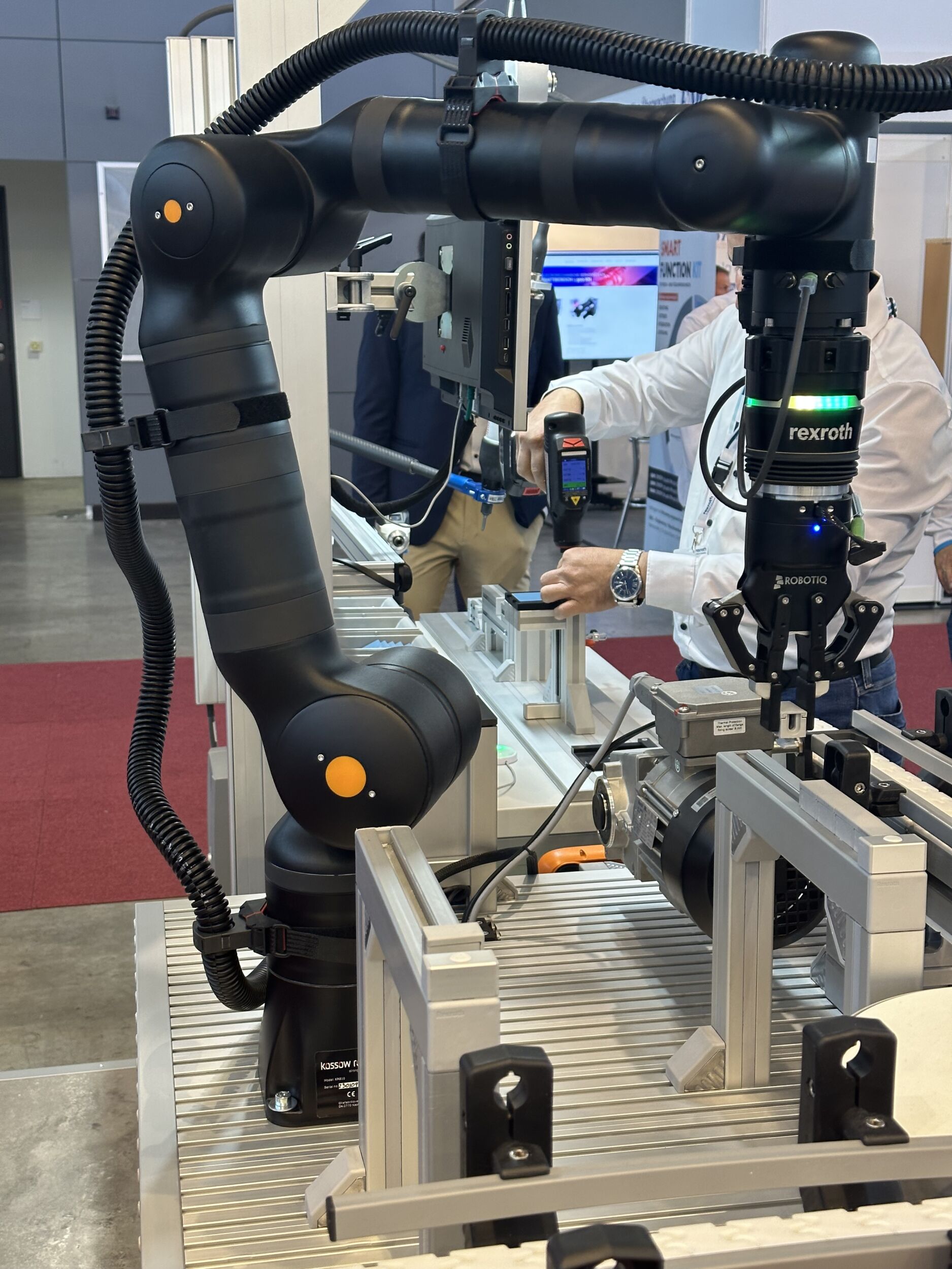 Bei PTS identifiziert der Cobot KR810 autonom verschiedene Bauteile, platziert sie auf dem Kettenförderband und positioniert sie für den nächsten Arbeitsschritt.