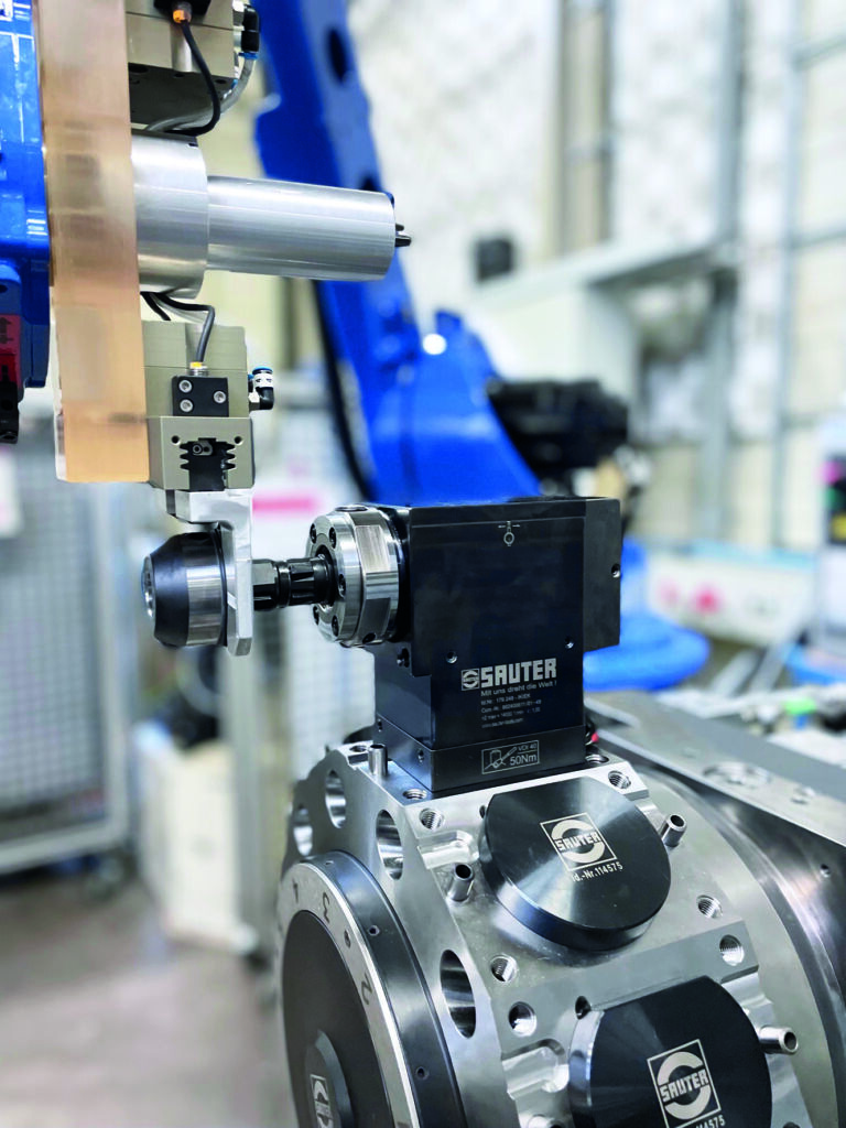 Einsparpotenziale für die Drehteilefertigung 3 Ein Robotergreifer setzt den Sauter SolidPro Adapter bei einem um 90° abgewinkelten Werkzeughalter auf Position ein.