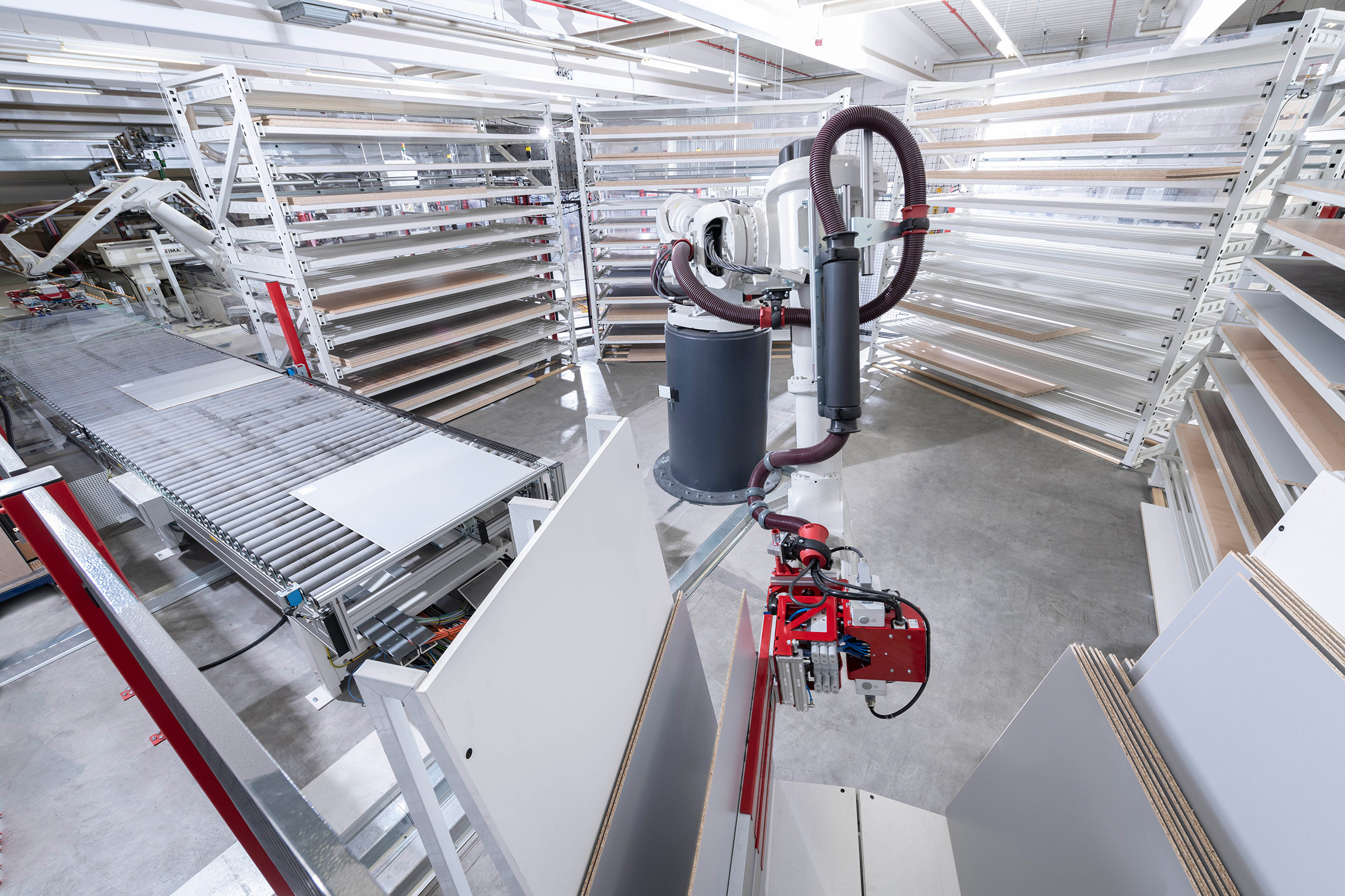 Eingebunden in eine Fertigungsanlage übernimmt der Roboter die Sortierung der Teile in Regale und einen Rückwandwagen (vorne im Bild).