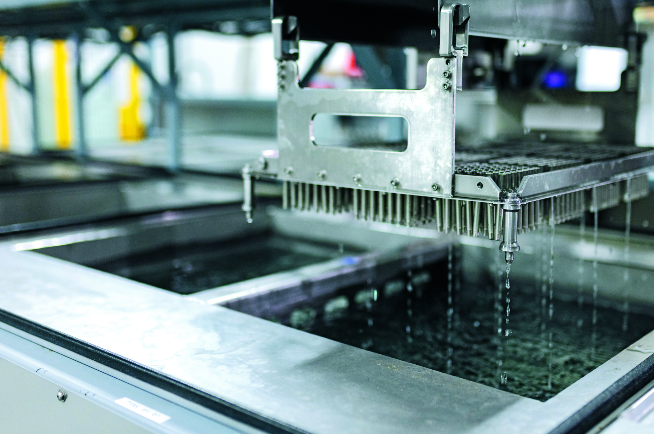 Vor und nach der CNC-Bearbeitung transportiert ein Portal die Werkstücke auf Trays durch verschiedene Bäder.