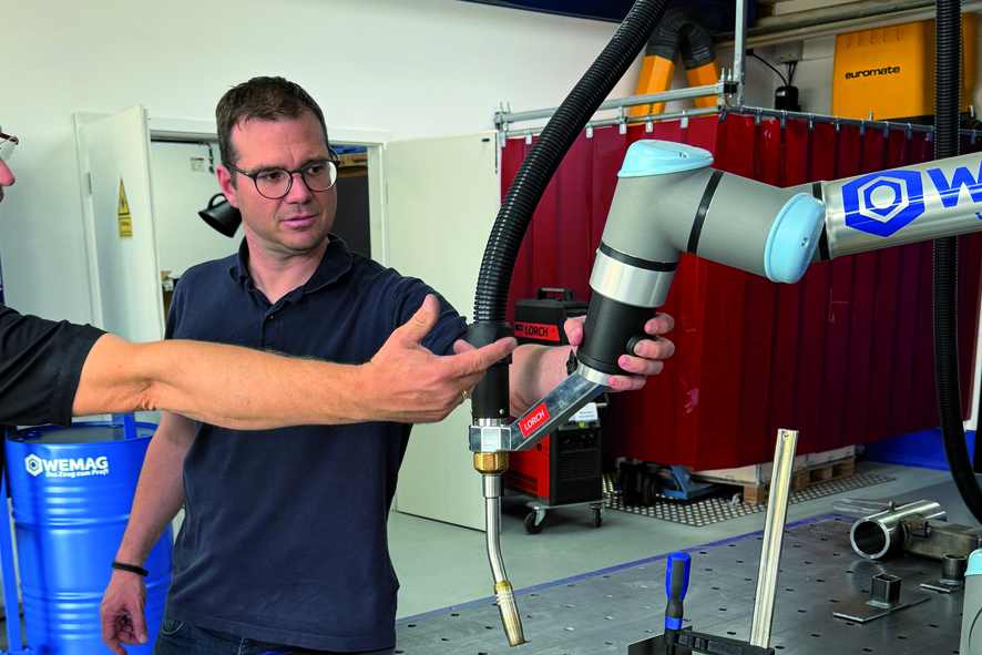 Christopher Schaus präsentiert einen Roboter für kollaboratives Schweißen
