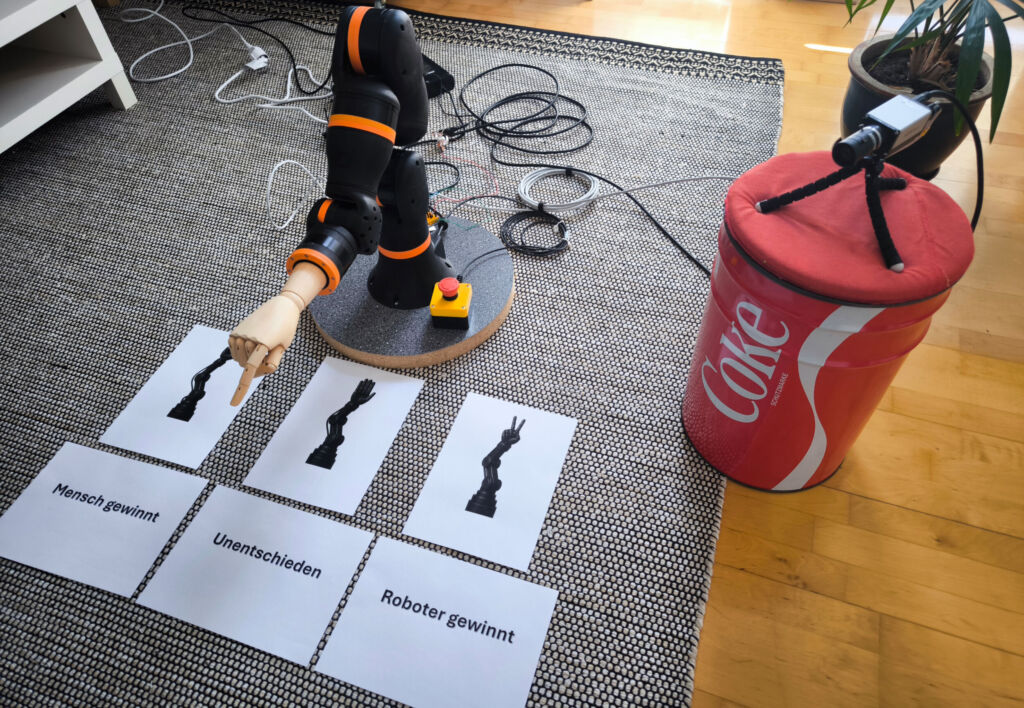 Gestenerkennung mittels Bildverarbeitung 2 Die Spielrunde verläuft in fünf Phasen: Erfassung der menschlichen Hand durch die Kamera, KI-basierte Bildauswertung, Roboterkommunikation und -bewegung, Ermittlung des Ergebnisses, Roboterkommunikation und -bewegung.