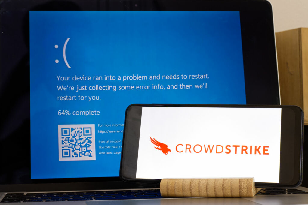 CrowdStrike logo and blue computer screen during mass tech outages worldwide have caused IT systems to shut down Microsoft system error caused by CrowdStrike