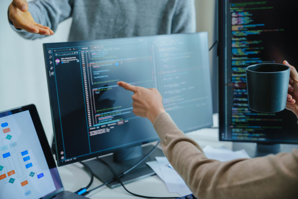 Was macht eigentlich ein Softwaretester? 1 asian and Indian Developer team discussion feedback analysis coding data with software computer at office