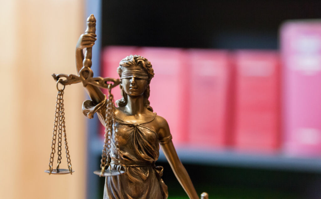 BSI bewirbt sich um Marktaufsicht für vernetzte Produkte 1 Justitia vor Buecherregal mit Gesetzbuechern