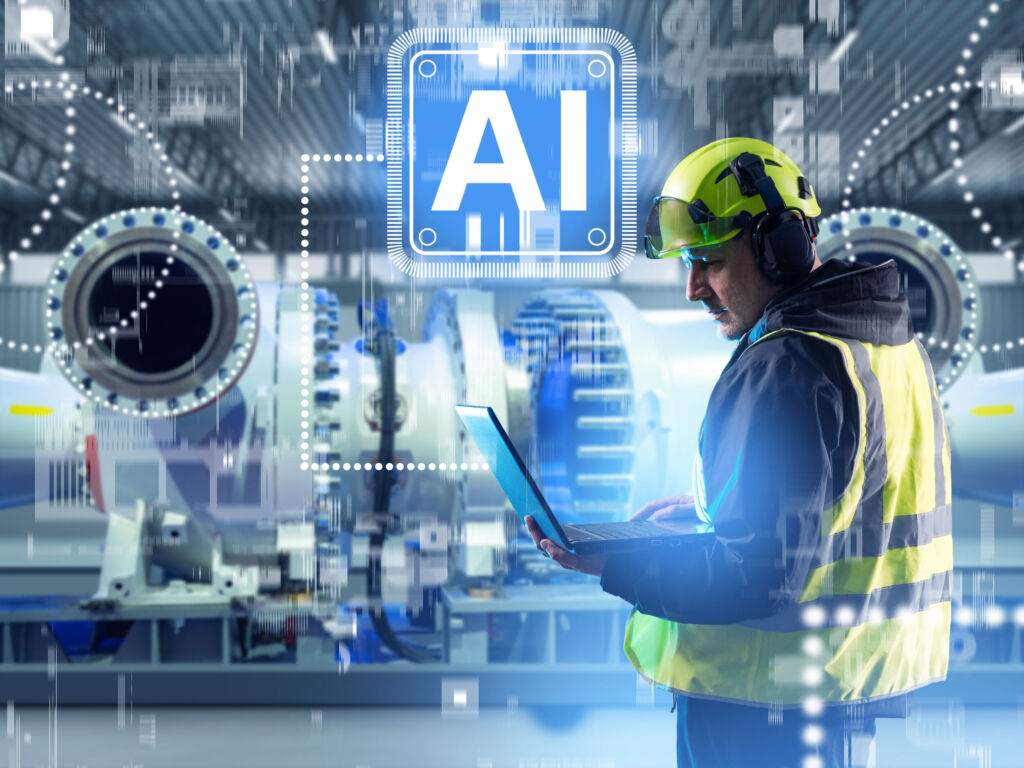 Grundlagen für KI-Rollouts in der Produktion 1 Engineer using laptop with AI technology in modern factory digital monitoring predictive maintenance machine learning automation. Manufacturing Engineering Artificial Intelligence
