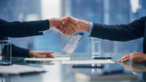 Female and Male Business Partners Sign Successful Deal Documents and Shake Hands in Meeting Room Office. Corporate CEO and Investment Manager Handshake on a Lucrative Financial Opportunity