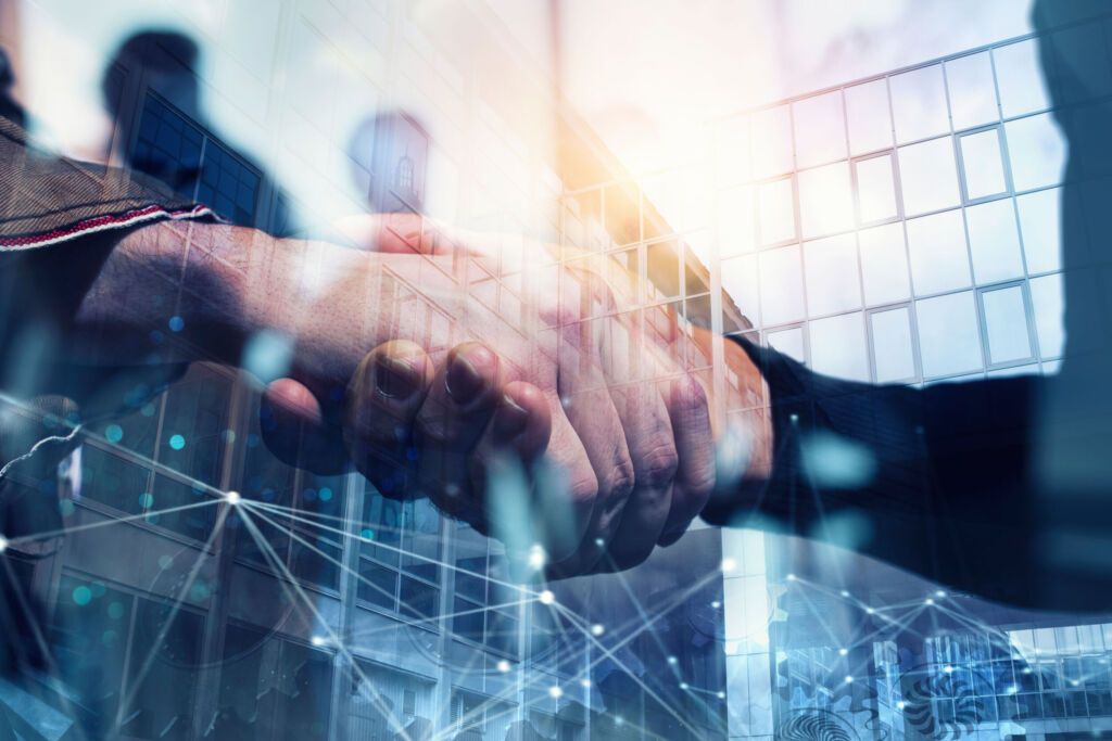 Schneider Electric übernimmt PTC 1 Handshaking business person in the office with network effect. concept of teamwork and partnership. double exposure